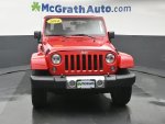 2014 Jeep Wrangler Sahara — Flame Red Clearcoat exterior view 5, for sale at McGrath Ford in Hiawatha, IA